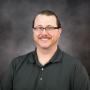 A photo of Andrew R Johnson in a grey shirt and glasses.