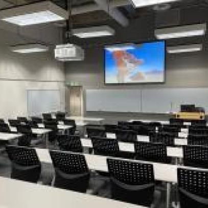 Image of large lecture hall with screen at front of room
