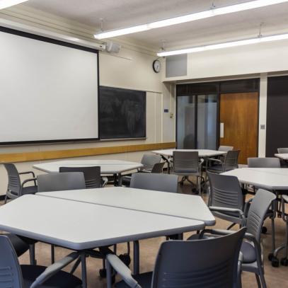 View of Projection screen and collaborative tables with seating