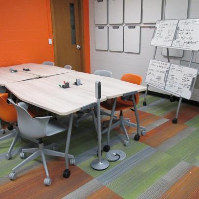4 huddle tables and chairs with wall of whiteboards
