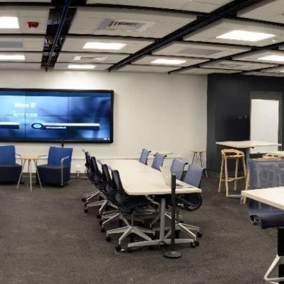 wide shot of room, group work tables with main projection at front